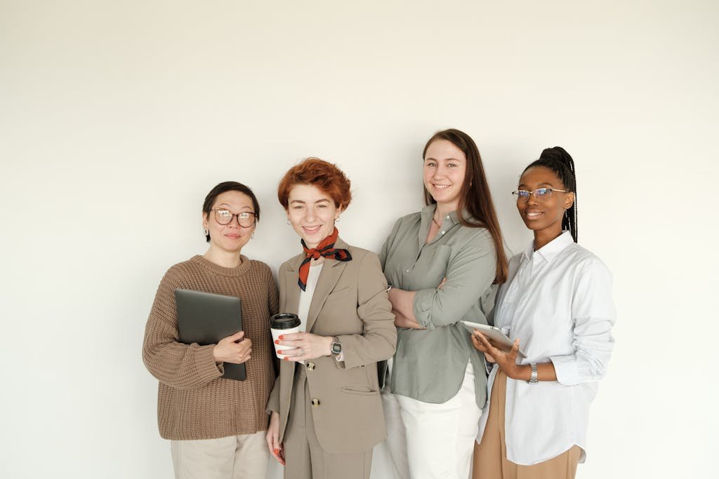 Group of professional women in business attire standing against a white background.
